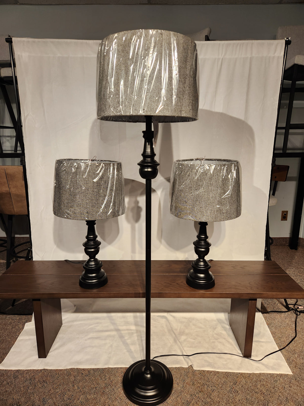 The Chandler 3 Piece Lamp Set by Adesso Lamp includes a bronze floor lamp and two table lamps with plastic-covered shades.