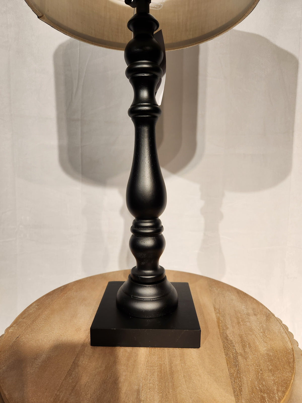 Adesso Lamp Zeek Table Lamp with black rubberwood base and 3-way rotary socket switch on a round wood surface.