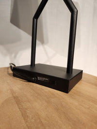 Close-up of Ashley Brookthrone Metal Table Lamp base with USB-C port and power cord on a wooden surface.