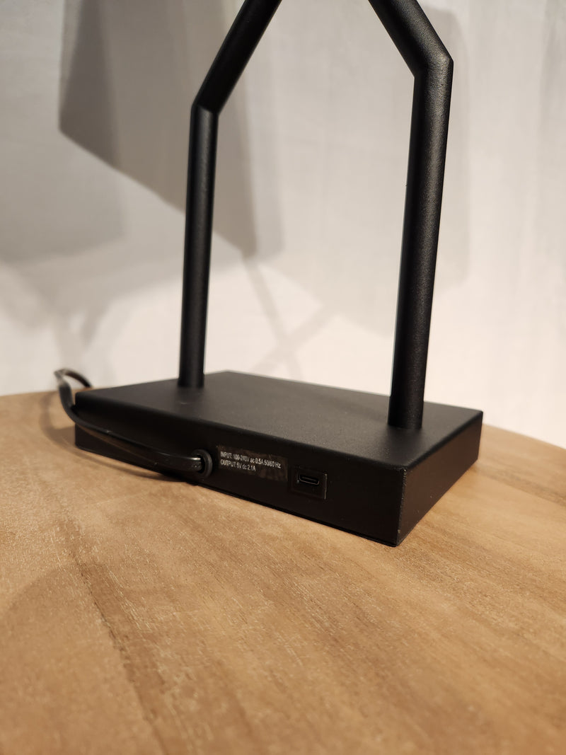 Close-up of Ashley Brookthrone Metal Table Lamp base with USB-C port and power cord on a wooden surface.