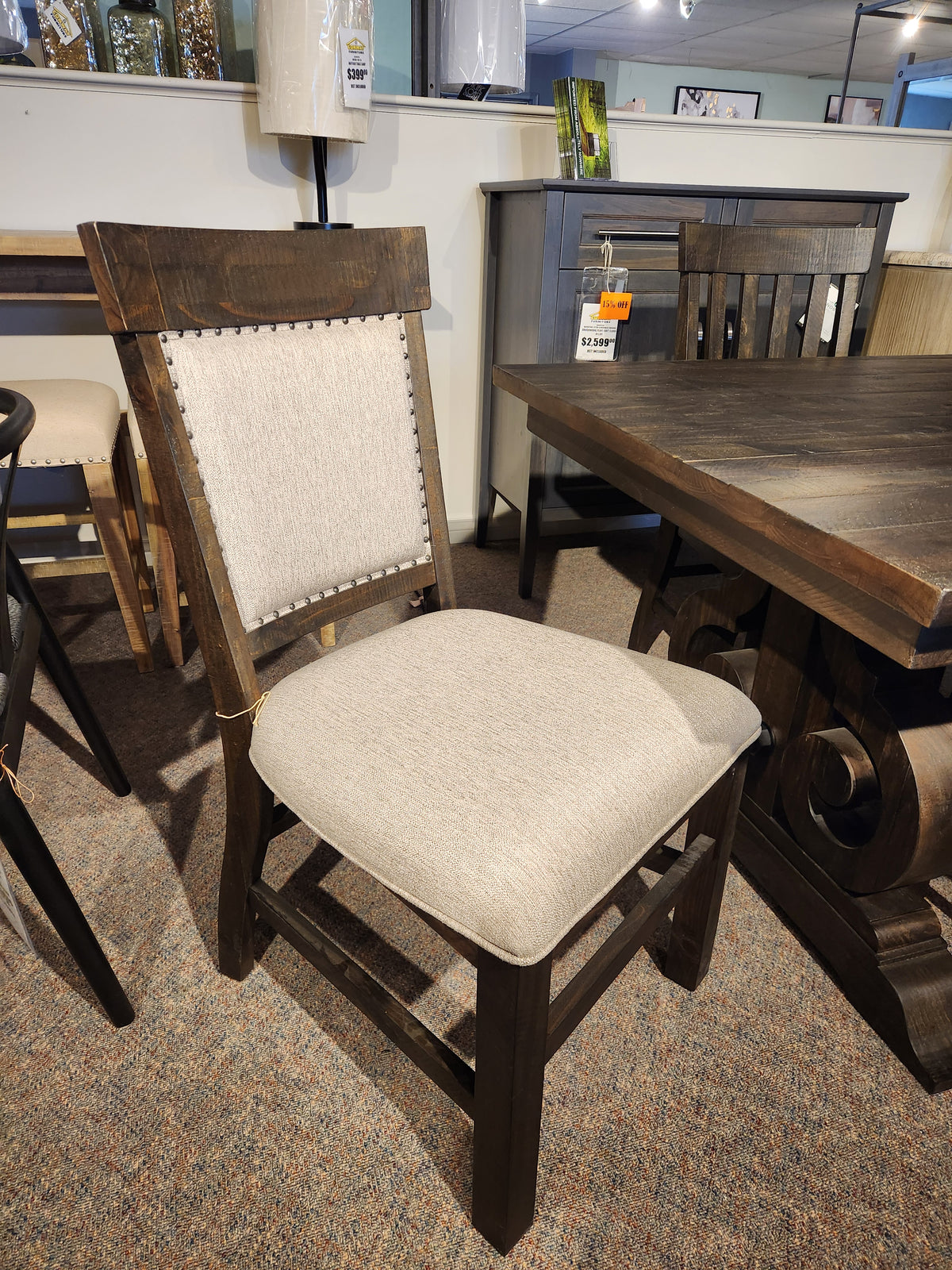 Beige-upholstered wooden dining chair, shown by Magnussen's 2491 Bellamy Dining Package in the showroom.