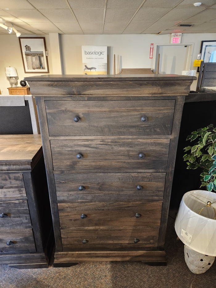 The Vokes 262-405 Bayshore chest, featuring five drawers and an ebony finish, is displayed in the showroom.