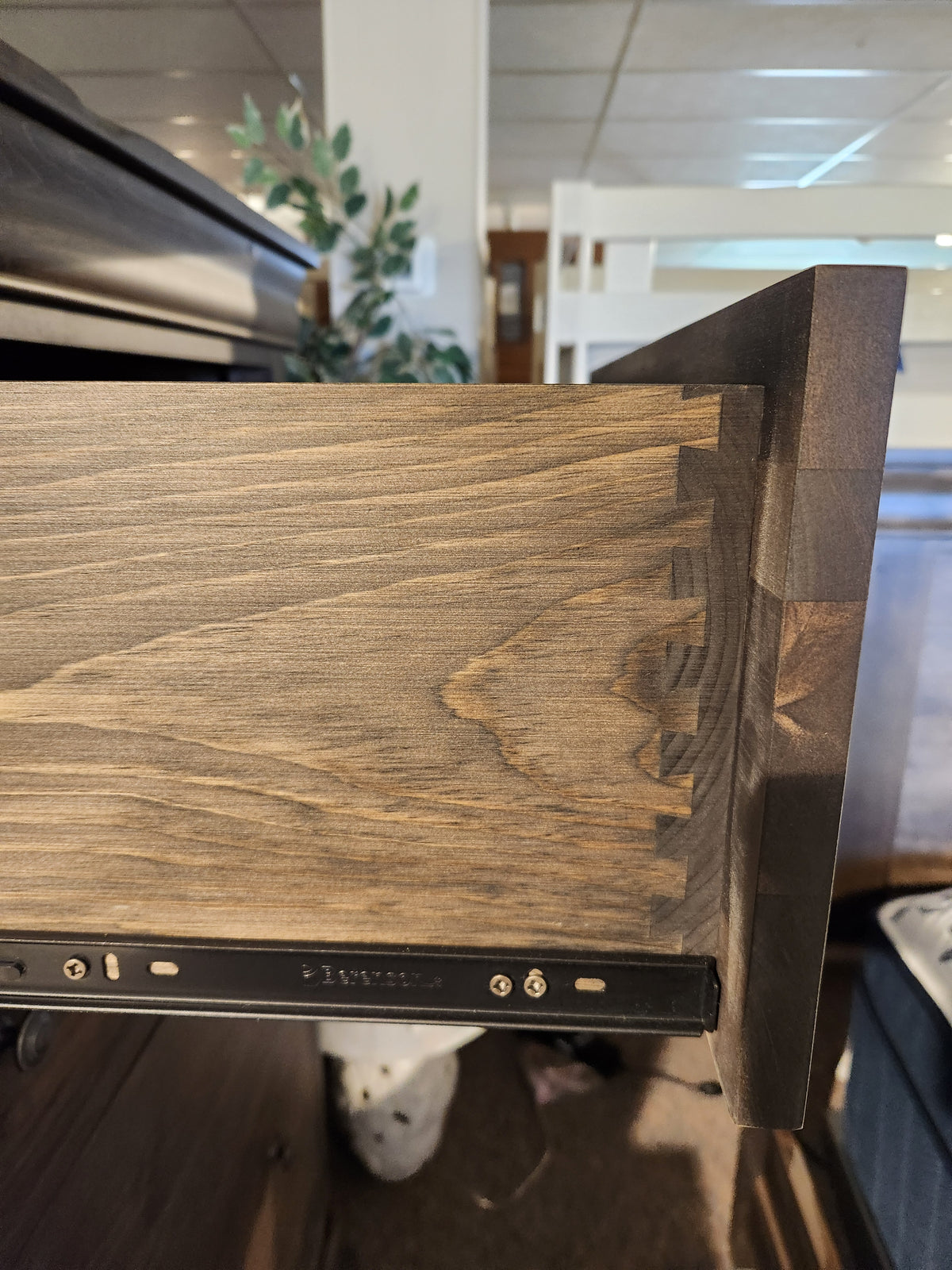 A drawer in the Vokes 262-405 Bayshore 5 Drawer Chest is open, showing dovetail joints and a metal sliding track.