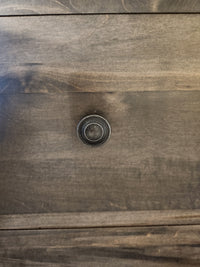 Close-up of a wooden drawer with a round metal knob on the Vokes 262-407 Bayshore 7 Drawer Dresser.