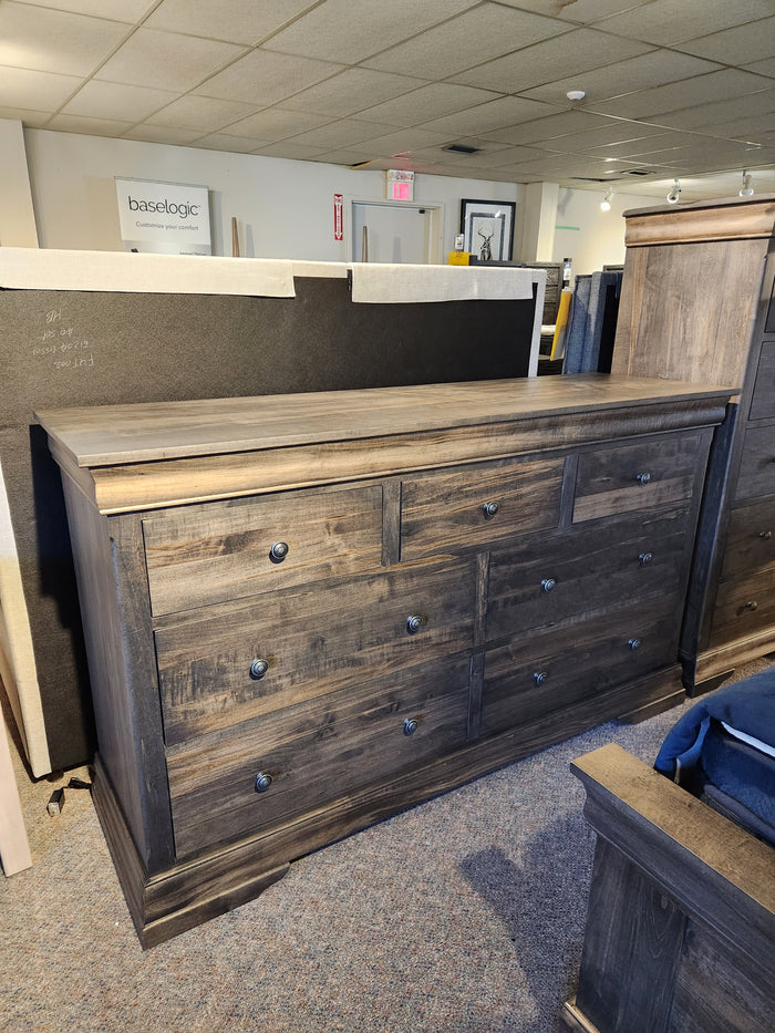 The Vokes 262-407 Bayshore 7 Drawer Dresser is displayed in a carpeted furniture showroom.