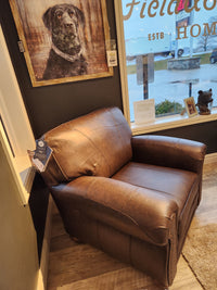 The Best Field & Stream Noble Chair, in brown leather, evokes modern lodge style by the window under a dog portrait.
