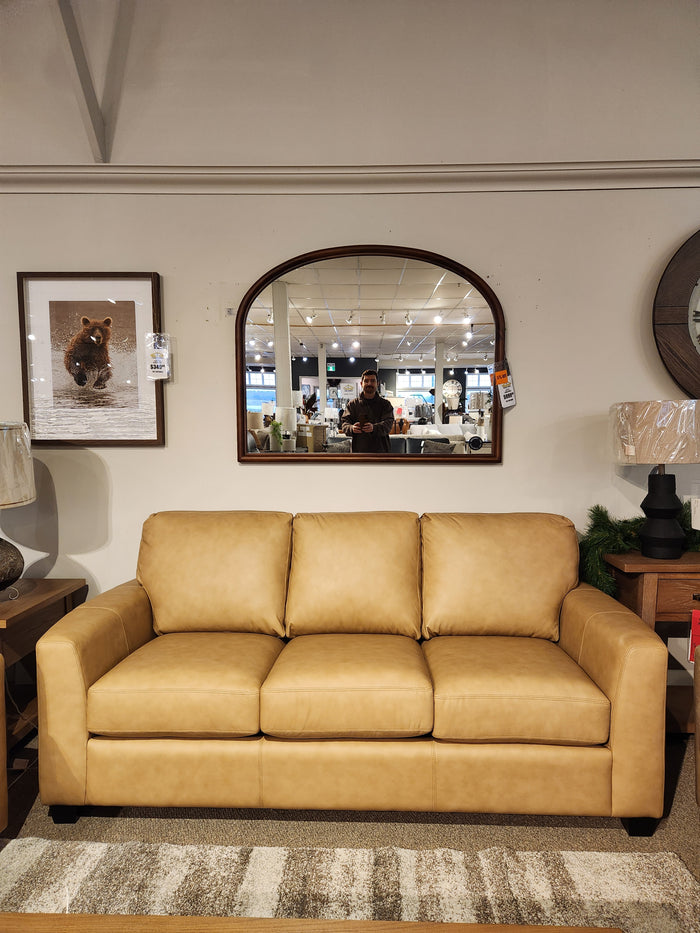 Tan leather Decor-rest 3968 Sofa with deep seats in showroom, large mirror and lamps behind; person visible in mirror.