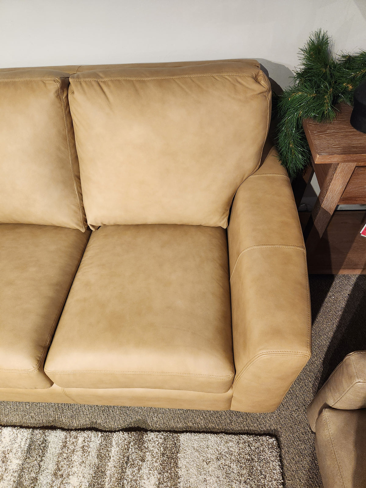 The Decor-rest 3968 Sofa in tan leather with deep seats sits beside a wooden side table and green plant.