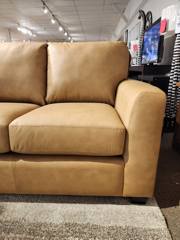 Decor-rest 3968 Loveseat in tan leather with deep seats and wide armrests, shown on beige carpet in showroom.