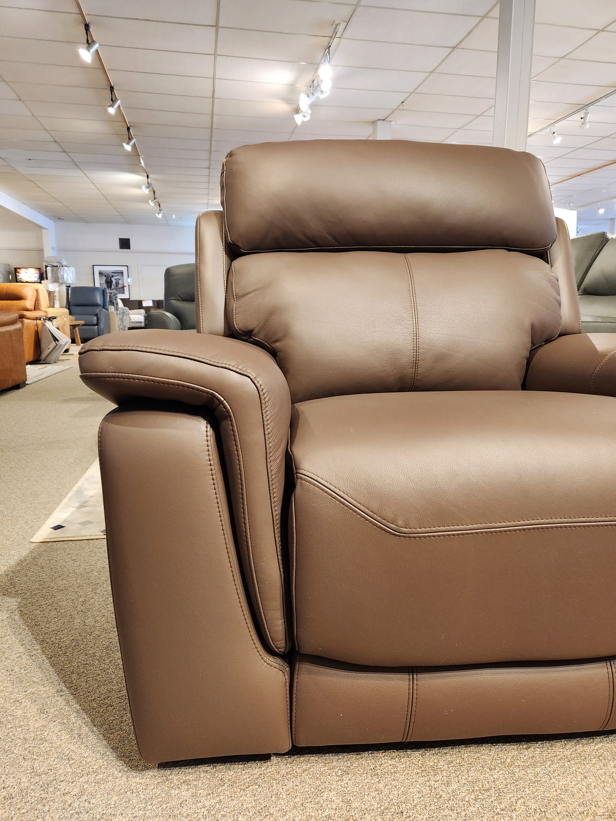 The Palliser 41051 Henry Wall-hugger Reclining Chair is showcased among other living room pieces in our showroom.