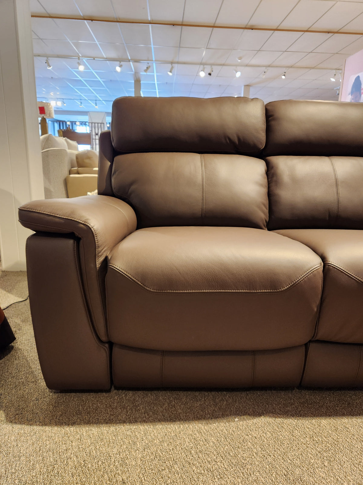 Palliser 41051 Henry Sofa with brown leather power recline displayed on carpet in a showroom with other furniture.