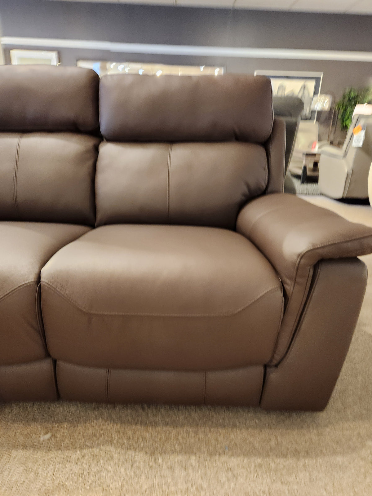 Palliser 41051 Henry Loveseat in brown leather with power headrest on display among art and other showroom furniture.