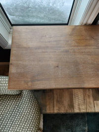 A 2028 Carrington Small Breakfront Cabinet by Jofran sits beside a snowy window, next to a patterned chair.
