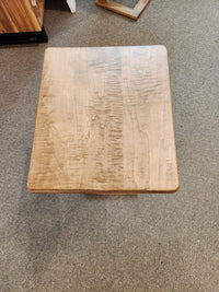 The Handstone AlaCarte Outback Snack Table with a light brown finish sits on a gray carpeted floor.