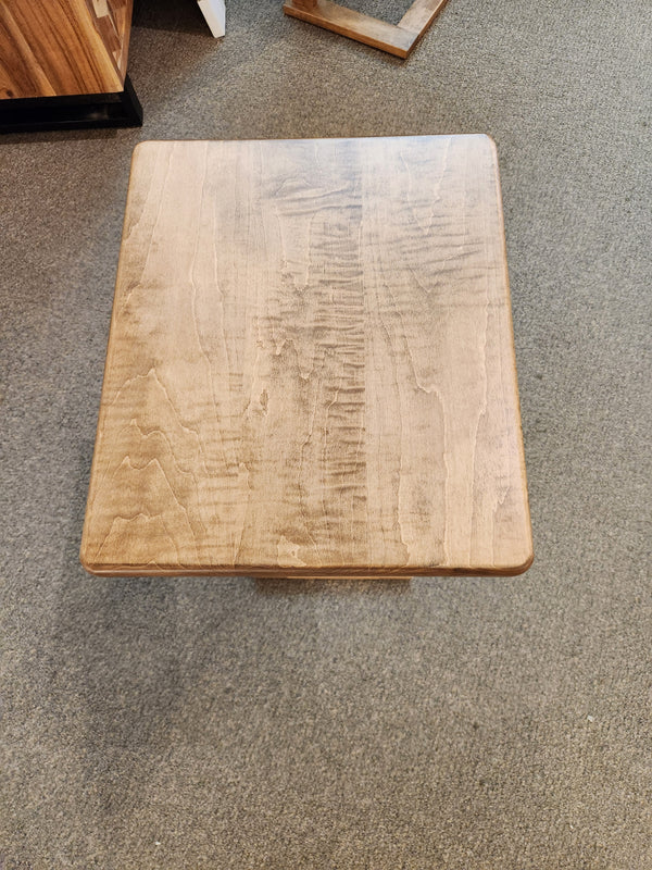 The Handstone AlaCarte Outback Snack Table with a light brown finish sits on a gray carpeted floor.