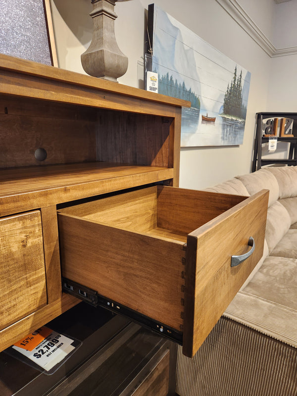 A Handstone Glengarry HDTV Cabinet drawer opens, displaying handcrafted detail and rustic furniture charm.