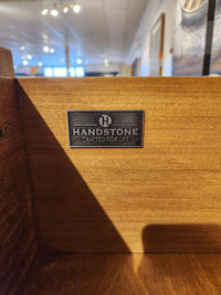 A metal plaque on the Glengarry HDTV Cabinet by Handstone displays the "Crafted for Life" logo.