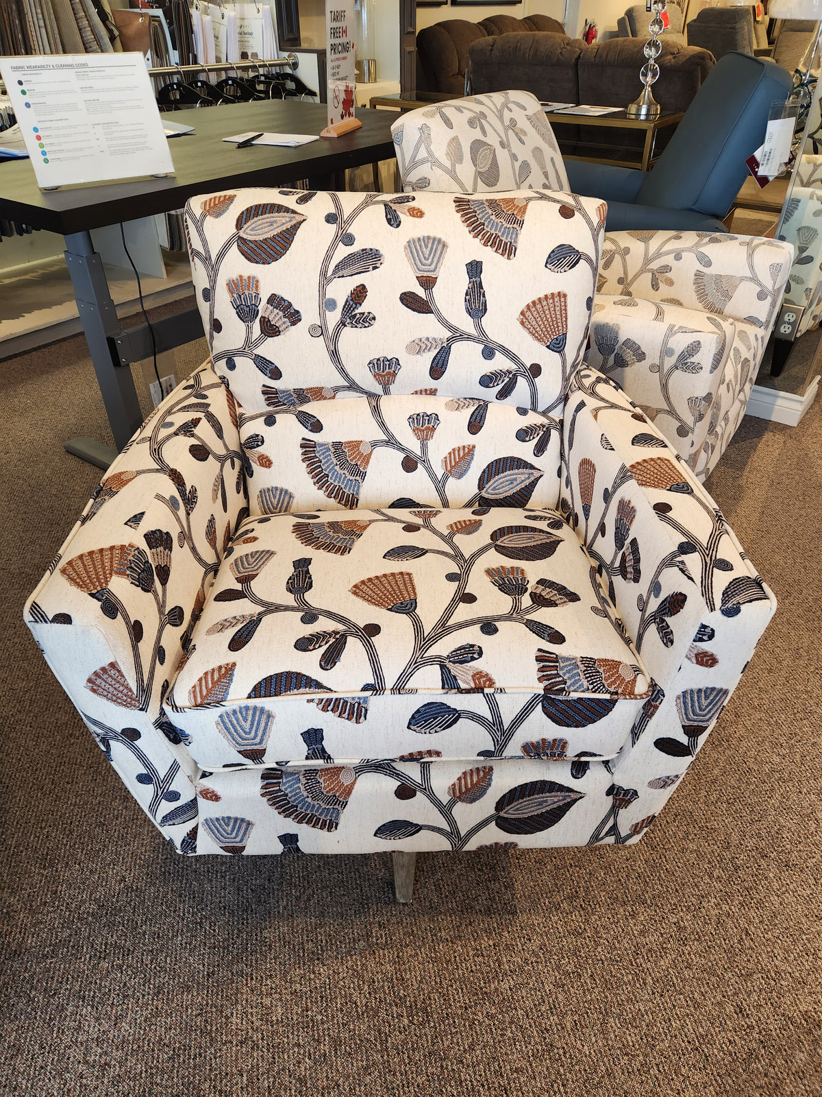 The La-Z-Boy 421-210 Bellevue High Leg Swivel Chair features floral upholstery, showcased among stylish showroom chairs.