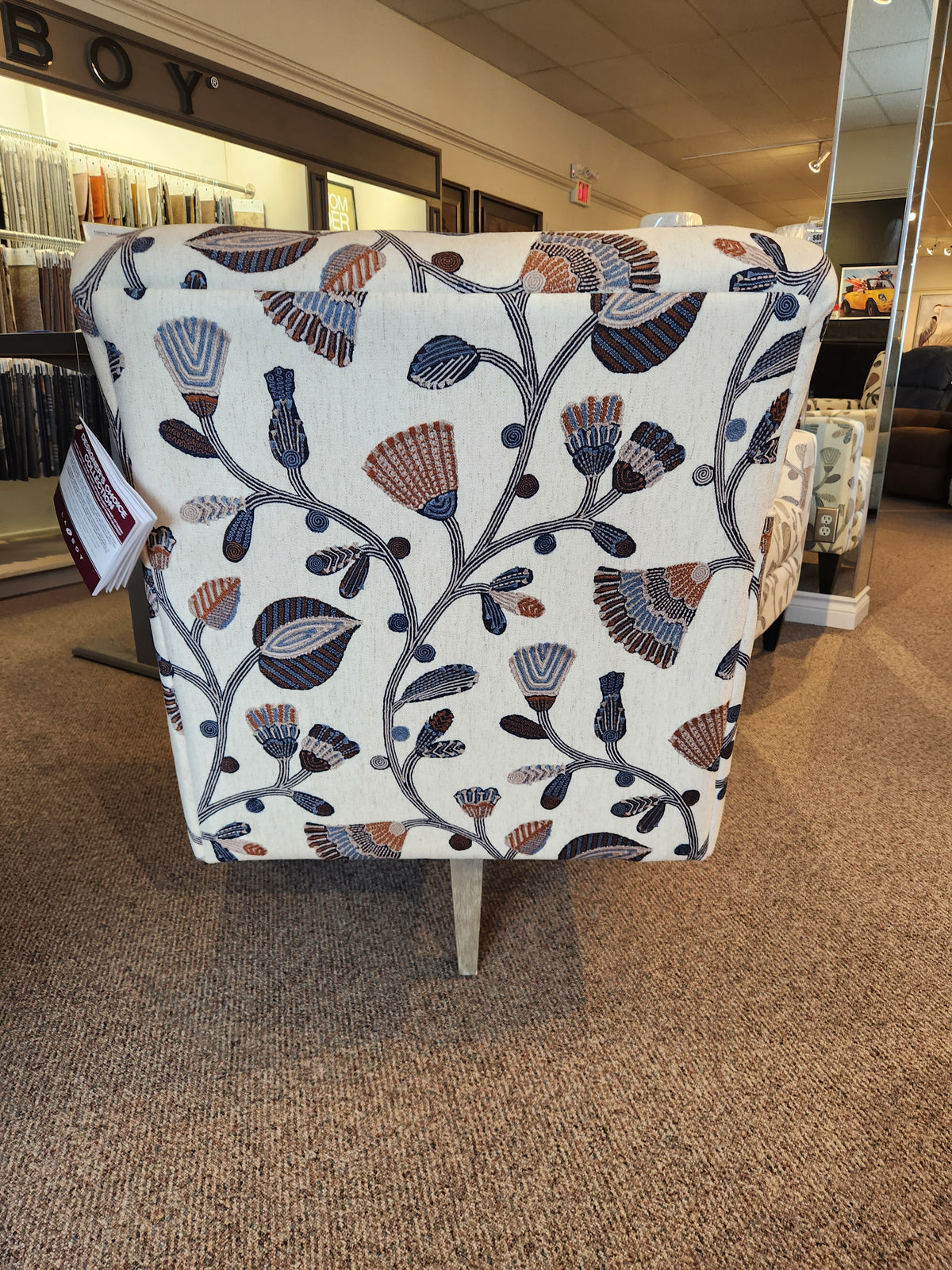 The La-Z-Boy 421-210 Bellevue High Leg Swivel Chair is showcased in a carpeted furniture showroom.