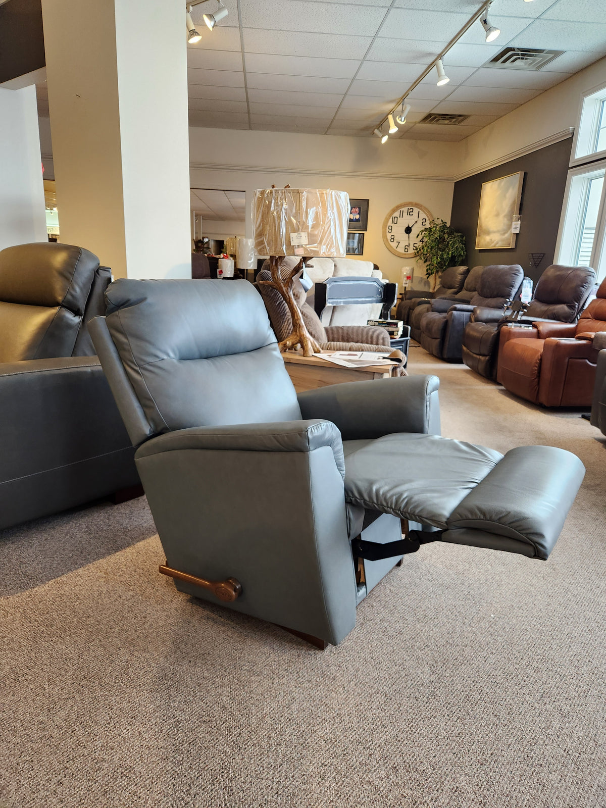 The La-Z-Boy 820 Norton Rocker Recliner in gray with ergonomic design and extended footrest is displayed in a showroom.