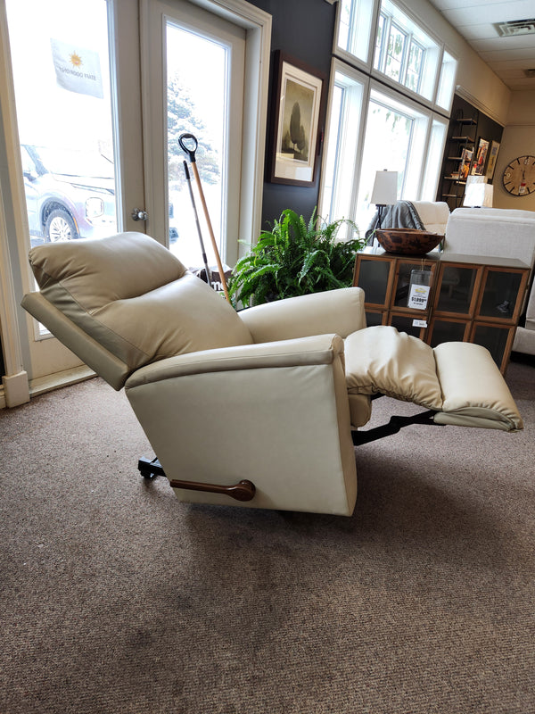 The La-Z-Boy 820 Norton Wall-A-Way Recliner in beige is displayed in a showroom with windows, plants, and chairs.