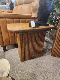 The Handstone Lotus Chairside Table features a classical slat base beside a tan sofa and decorative accents.