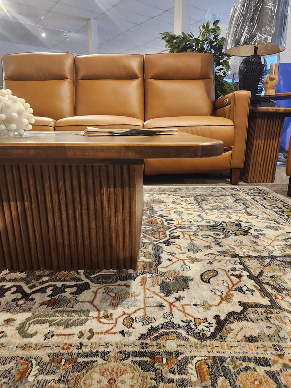 The Handstone Lotus Coffee Table and a brown leather sofa add elegant style to this modern living room.