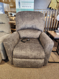 The La-z-boy 793 Jean Bronze Lift Chair in gray is shown with a remote control in a furniture store showroom.