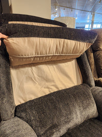 A hand lifts the back cushion of the La-z-boy 519 Astor Rocker Recliner, showing the inner lining and support structure.