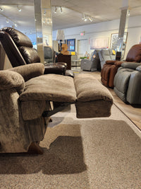 The La-z-boy 519 Astor Rocker Recliner, brown, with adjustable backrest and footrest, shown in a furniture showroom.