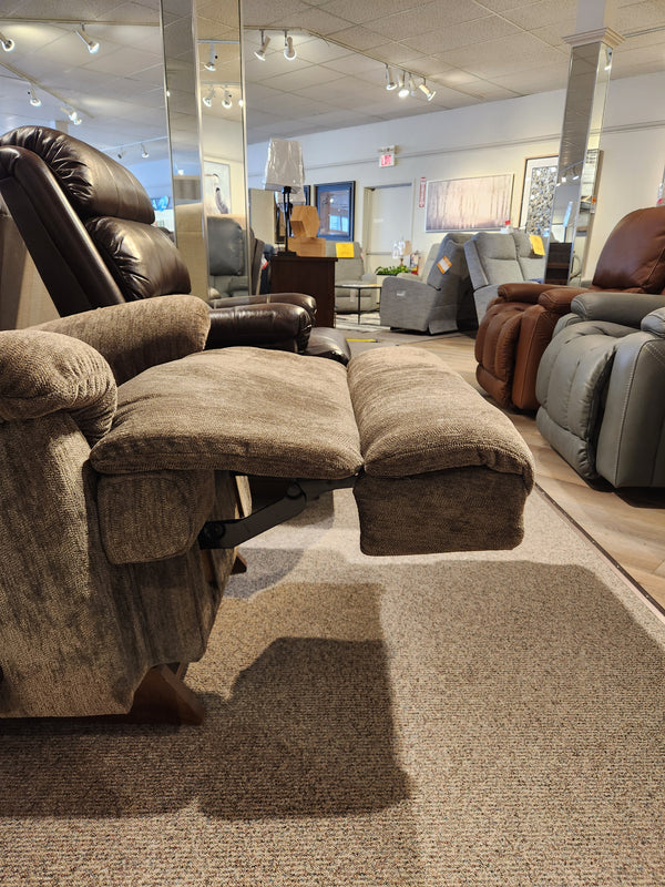 The La-z-boy 519 Astor Rocker Recliner, brown, with adjustable backrest and footrest, shown in a furniture showroom.