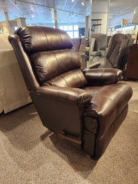 A La-z-boy 519 Astor Rocker Recliner in brown leather sits on carpet in a furniture showroom.