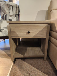 The Magnussen Conrad Rectangular End Table (T5865) has a Stone Harbor Grey finish, 1 drawer, and an open lower shelf.