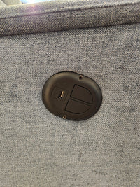 Close-up of a USB charging port in the fabric of the gray Palliser 43003 Denali Swivel Power Glider chair.