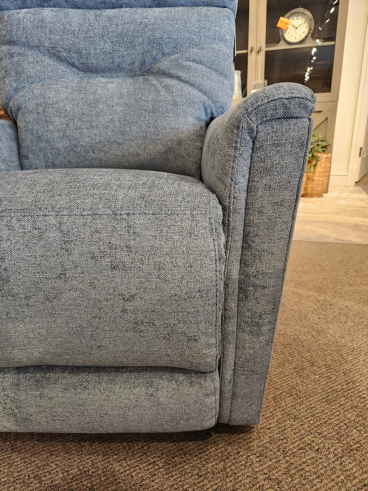 Close-up of the blue Palliser 43003 Denali Swivel Power Glider on a brown carpet, perfect for cozy living rooms.