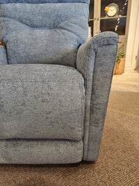 Close-up of the blue Palliser 43003 Denali Swivel Power Glider on a brown carpet, perfect for cozy living rooms.