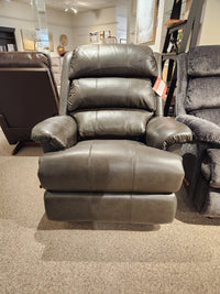 A La-z-boy 519 Astor Rocker Recliner in dark gray leather is shown on a beige carpeted showroom floor.