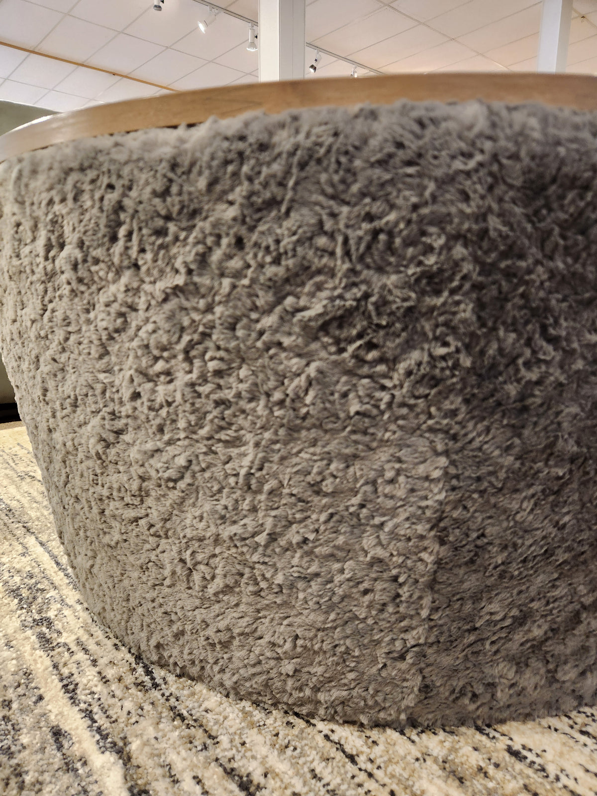 A close-up of the Decor-rest 6415 Lift Top Storage Ottoman/Coffee Table on a patterned rug in a showroom.