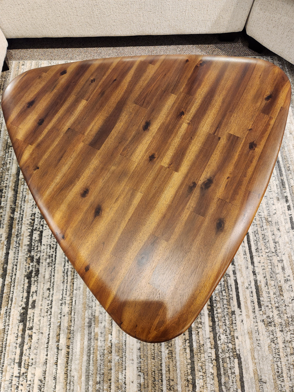 The Palliser 7110 Kacia Tri Coffee Table features rounded edges atop a patterned rug, surrounded by light upholstery.