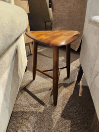 The Palliser 7110 Kacia Tri end Table in solid acacia wood sits on carpet between upholstered chairs.