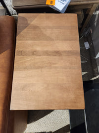 Durham 905- 16" x 24" End Table in Aged Wheat, shown beside a brown leather seat.