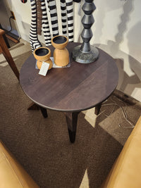 Durham 905-24" round table in Java, styled with two wooden vases, lamp, and striped decor on tan carpet.