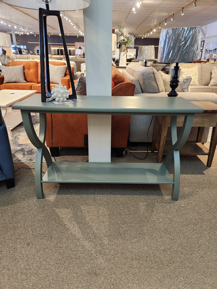 The Durham 900- Transitional Sofa Table features curved legs, a lower shelf, and a green finish for showroom appeal.