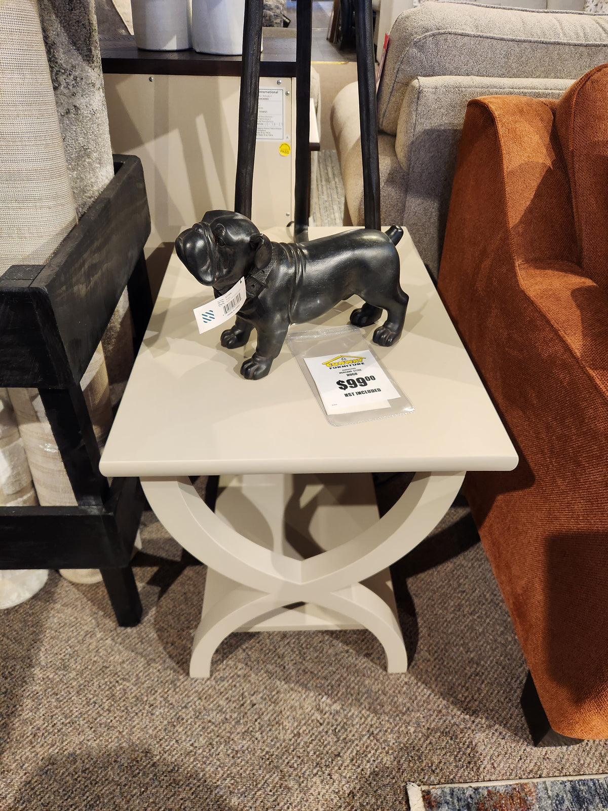 A Durham 900-534 Transitional End Table features a black dog figurine and price tag in a showroom display.