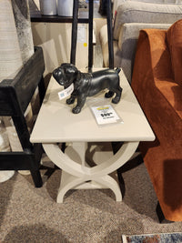 A Durham 900-534 Transitional End Table features a black dog figurine and price tag in a showroom display.