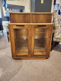 Handstone Lotus Dining Sideboard with pot lights features glass doors, two shelves, and vertical panel detail on carpet.