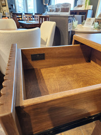 Open wooden drawer of the Handstone Lotus Dining Sideboard with Pot Lights, seen in a stylish furniture showroom.