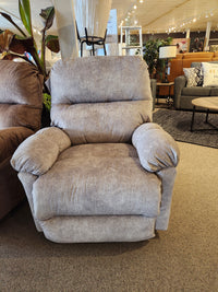 A gray Best 7MP84 Ellisport Power Space Saver Recliner is displayed in a showroom with other seating in the background.