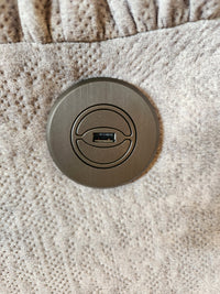 Close-up of the circular USB port in gray fabric on the Best 7MP84 Ellisport Power Space Saver Recliner.