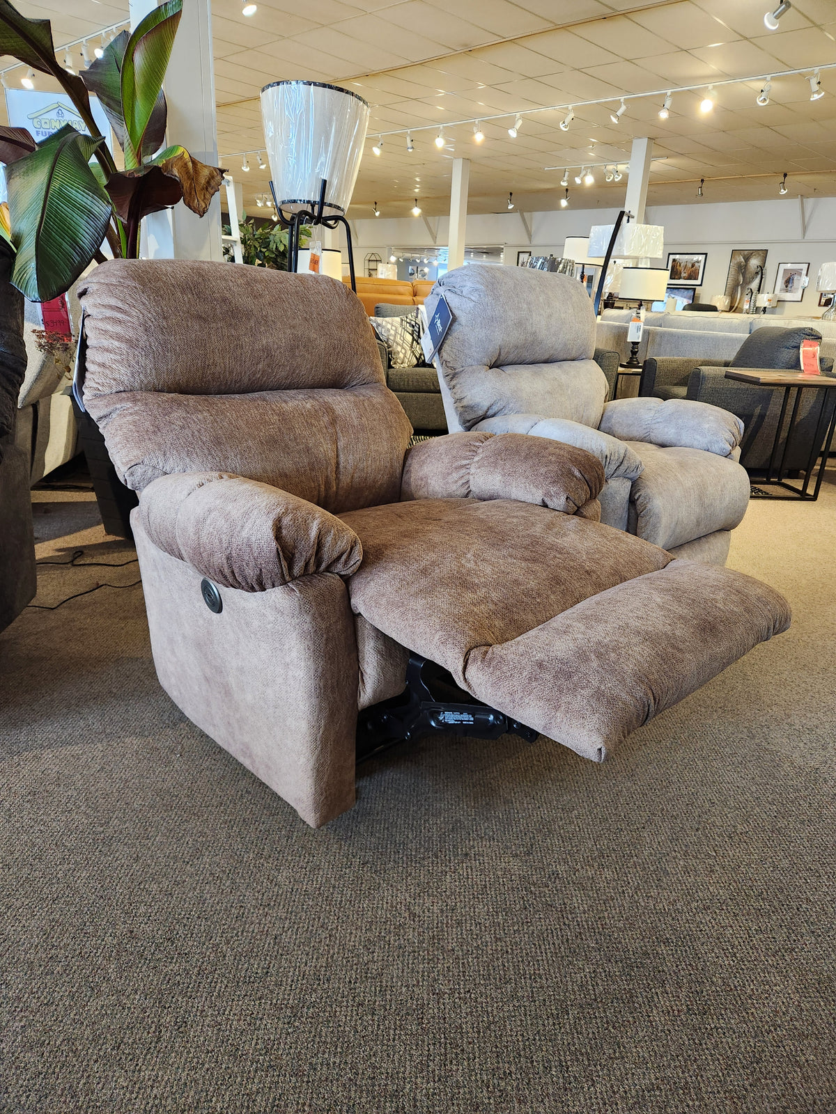 The Best 7MP84 Ellisport Power Space Saver Recliner in brown with footrest extended is shown in a showroom.